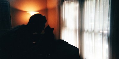 Young girl and cat touching noses