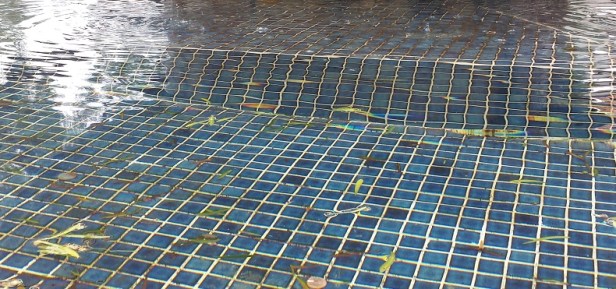 The blue tiled bottom of a fountain at a centuries old California mission