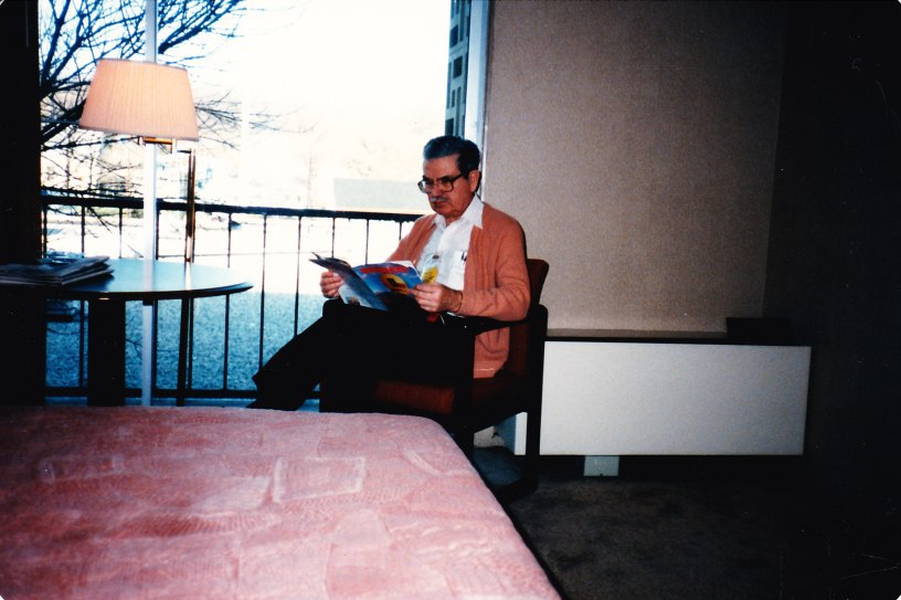 Grandfather reading a magazine in a hotel
